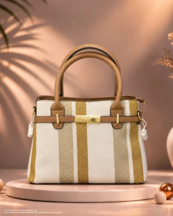 White and gold striped handbag with tan leather handles and gold hardware.
