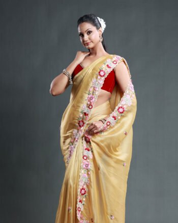 Beige organza saree with vibrant floral embroidery and scalloped border details