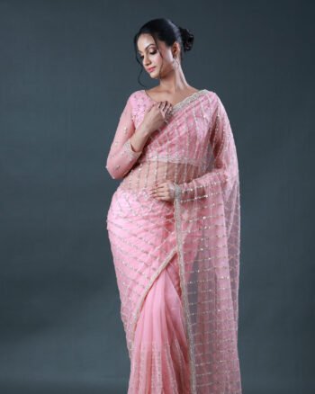 Light pink net saree featuring linear sequin embellishments and an embellished silver border