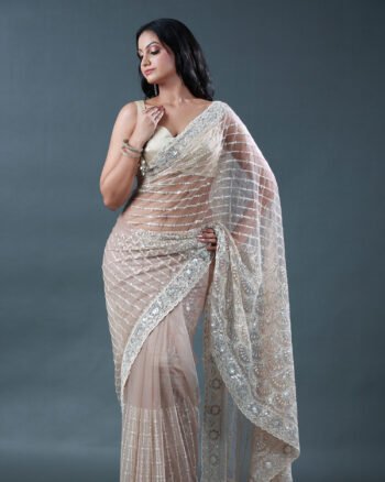 Champagne beige net saree with silver sequin geometric patterns and an embroidered scalloped border