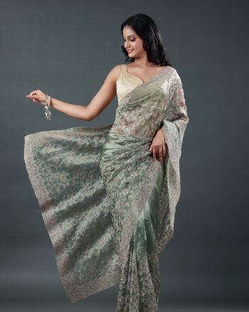 Sage green organza saree featuring delicate silver thread floral embroidery throughout with an embellished border