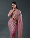 Dusty pink net saree featuring heavy silver sequin and bead embellishments in wavy, vertical patterns