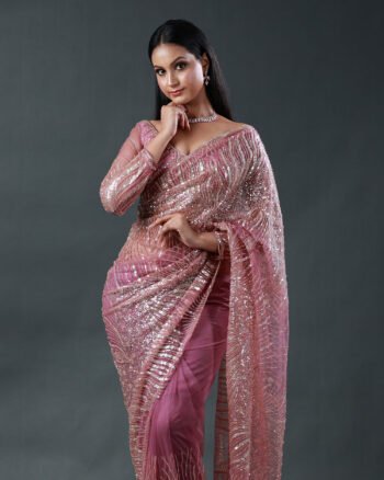 Dusty pink net saree featuring heavy silver sequin and bead embellishments in wavy, vertical patterns