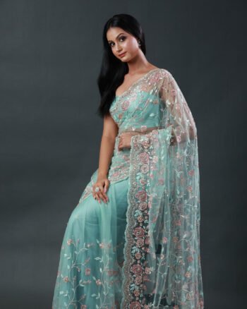 Mint green net saree featuring pastel pink and gold floral embroidery with scalloped edges